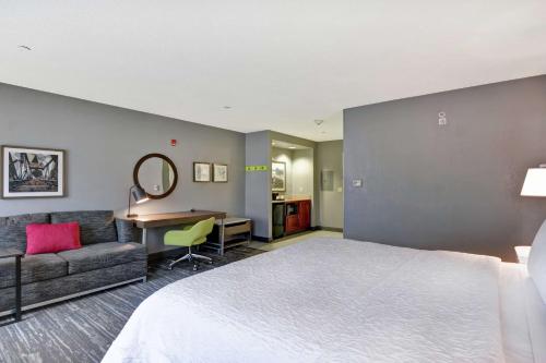 纽瓦克纽瓦克哈里森河滨希尔顿恒庭旅馆&套房酒店的配有一张床和一张书桌的酒店客房