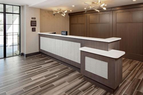 朗康科马Homewood Suites By Hilton Ronkonkoma的办公大厅设有前台和木地板