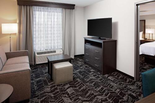 朗康科马Homewood Suites By Hilton Ronkonkoma的配有一张床和一台平面电视的酒店客房