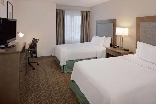 布卢明顿Homewood Suites by Hilton Minneapolis-Mall Of America的酒店客房设有两张床和一台平面电视。