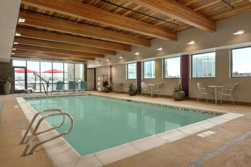 南乔丹盐湖城/南约旦希尔顿欣庭套房酒店的大楼内带桌椅的大型游泳池