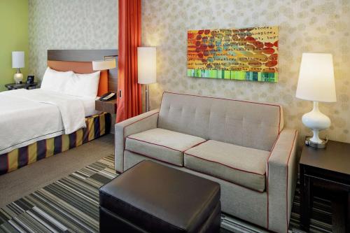 南乔丹盐湖城/南约旦希尔顿欣庭套房酒店的酒店客房,配有床和沙发