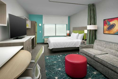 纳什维尔Home2 Suites By Hilton Nashville Downtown Convention Center的酒店客房,配有床和沙发