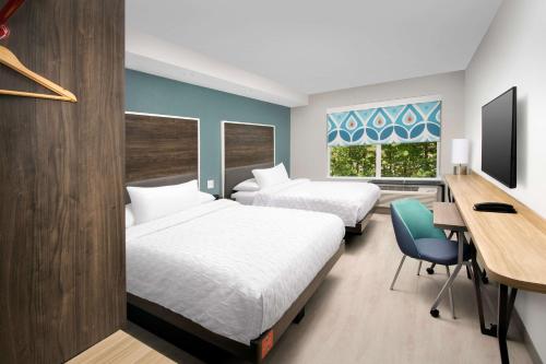 塔拉哈西Tru By Hilton Tallahassee Central的酒店客房设有两张床、一张桌子和一台电脑。