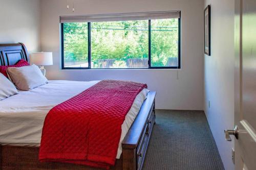 塞多纳Cowboys & Angels - Classic Sedona style w/great location的一间卧室配有一张带红色毯子的床和窗户。