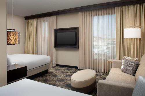 诺克斯维尔Embassy Suites by Hilton Knoxville West的酒店客房,配有床和电视