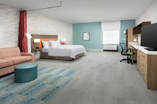 哥伦比亚Home2 Suites By Hilton Columbia Southeast Fort Jackson的酒店客房,配有床和沙发