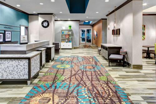 亚特兰大希尔顿亚特兰大周界邓伍迪汉普顿酒店及套房的大堂的地板上铺着色彩缤纷的地毯