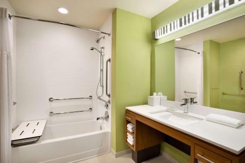 伯明翰伯明翰市中心希尔顿住宅2套房酒店的一间带水槽、浴缸和淋浴的浴室