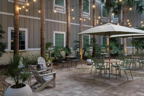 新士麦那海滩新士麦那海滩汉普顿酒店的一个带桌椅和遮阳伞的庭院