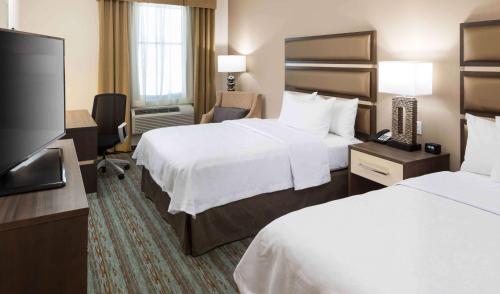 卡纳维拉尔角卡纳维拉尔角-可可比奇希尔顿惠庭套房酒店的酒店客房设有两张床和一台平面电视。