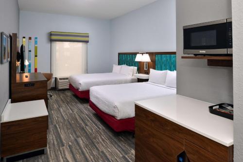 巴拿马城海滩Hampton Inn by Hilton Panama City Beach的酒店客房设有两张床和一台平面电视。