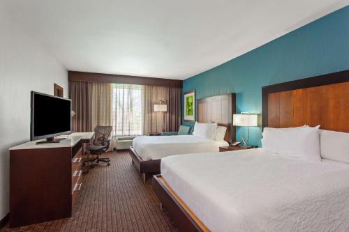维多利亚希尔顿花园酒店维多利亚的酒店客房设有两张床和一台平面电视。