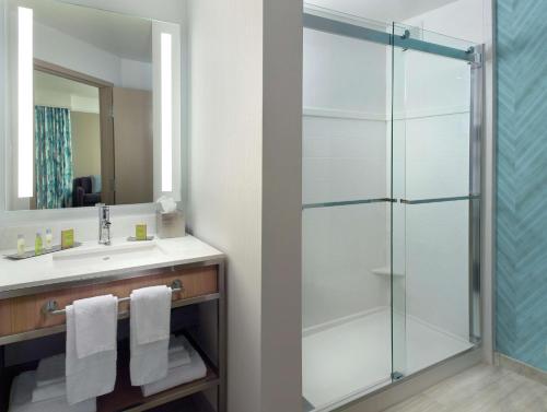 亚特兰大Hilton Garden Inn Atlanta-Buckhead的一间带玻璃淋浴和水槽的浴室