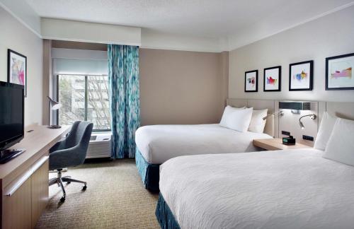 亚特兰大Hilton Garden Inn Atlanta-Buckhead的酒店客房设有两张床和一台平面电视。