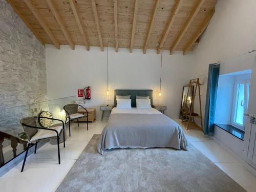 奥维多Villa Tité的一间卧室,卧室内配有一张床和椅子