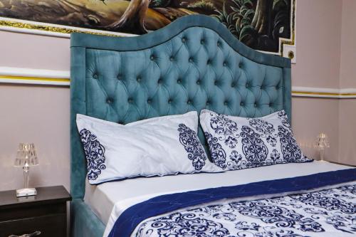 雅温得Hôtel The Place的一张带蓝色床头板和枕头的床
