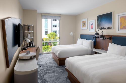 奥兰多The Celeste Hotel, Orlando, a Tribute Portfolio Hotel的一间酒店客房,设有两张床和电视