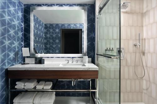 奥兰多The Celeste Hotel, Orlando, a Tribute Portfolio Hotel的一间带水槽、镜子和淋浴的浴室