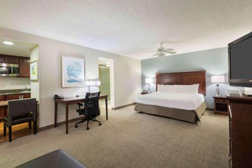 坦帕Homewood Suites by Hilton酒店坦帕机场 - 西岸的一间卧室配有一张床和一张带电脑的书桌