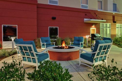 诺克斯维尔Hampton Inn & Suites Knoxville-Turkey Creek Farragut的大楼前设有带椅子和火坑的庭院