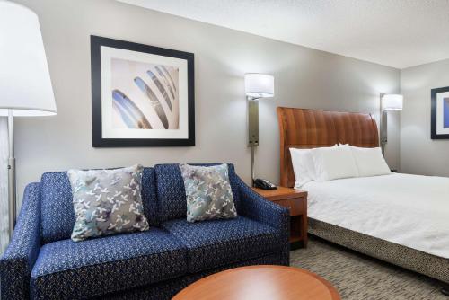 坦帕坦帕机场/韦斯特舒尔希尔顿花园酒店的酒店客房设有一张沙发和一张床