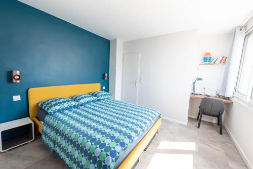 维勒班Happy 70's - Family Place的一间卧室配有一张蓝色墙壁的床