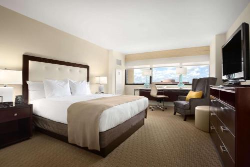 迈阿密迈阿密机场蓝色泻湖希尔顿酒店的酒店客房设有一张大床和一张书桌。