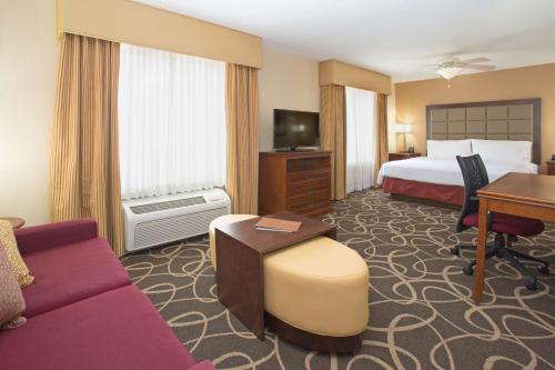 优马优马希尔顿惠庭套房酒店的配有一张床和一张书桌的酒店客房