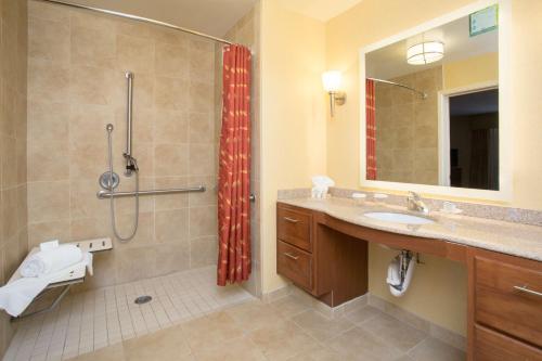 优马优马希尔顿惠庭套房酒店的带淋浴、卫生间和盥洗盆的浴室