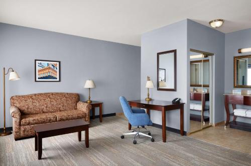 塔尔萨塔尔萨南部比克斯比汉普顿套房酒店的带沙发、书桌和椅子的客房