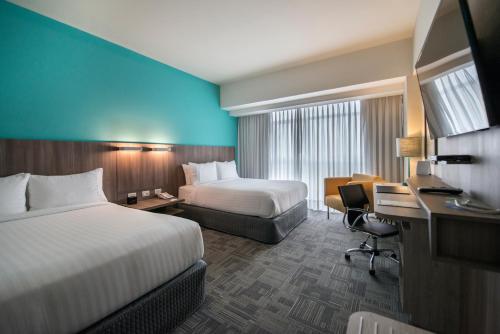 利马利马机场假日酒店的酒店客房配有两张床和一张书桌