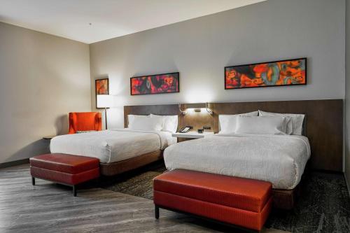 路易斯威尔Hilton Garden Inn Louisville Mall Of St. Matthews的酒店客房,配有两张床和椅子