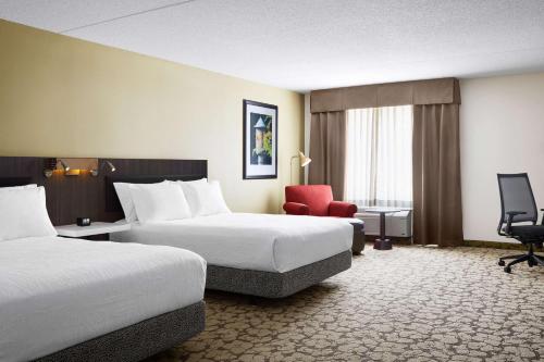 沃里克希尔顿花园酒店 普罗维登斯机场/沃里克的酒店客房,设有两张床和一张红色椅子