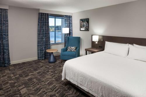 萨凡纳萨凡纳机场希尔顿花园酒店的酒店客房,配有一张床和一张蓝色椅子
