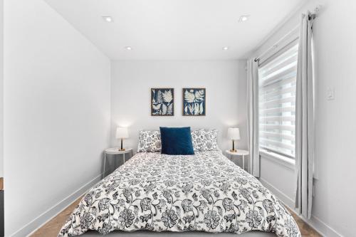 泰勒博恩Le Sainte-Marie - Vieux-Terrebonne的白色卧室配有一张带蓝色枕头的大床