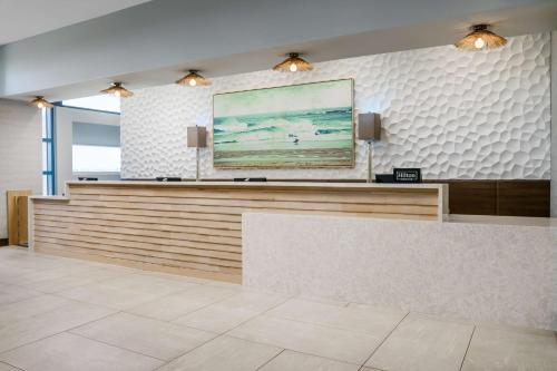 默特尔比奇Homewood Suites by Hilton Myrtle Beach Oceanfront的大堂设有前台,墙上挂有绘画作品