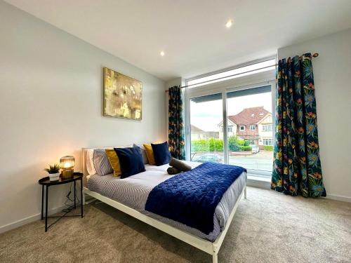 浦耳Brand New 3 Bedroom House -Sleeps 6 - Free Parking - Great Location - Fast WiFi - Smart TV - sleeps 6! Close to Poole & Bournemouth & Sandbanks的一间卧室设有一张床和一个大窗户