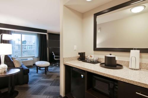 贝尔维尤贝尔维尤市中心/西雅图汉普顿酒店的酒店客房设有水槽和大镜子