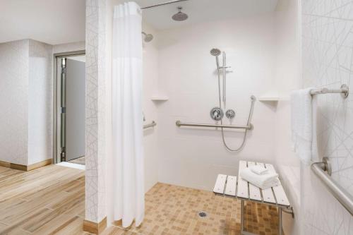 千橡市千橡市汉普顿套房酒店的带淋浴和长凳的白色浴室