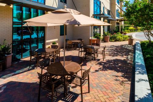 国家海港亚历山德里亚区纳什纳尔哈勃尔希尔顿恒庭旅馆&套房酒店的一个带桌椅和遮阳伞的庭院