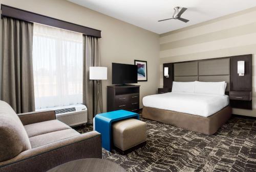 圣何塞圣何塞北部希尔顿惠庭套房酒店的酒店客房配有床、沙发和电视。