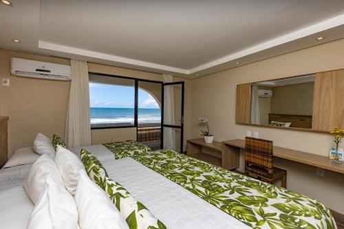伊列乌斯奥帕巴普拉亚酒店的一间卧室配有一张床、一张书桌和一个窗户。