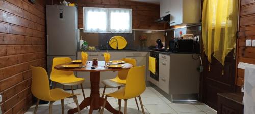 莱昂斯-达赫雷Studio les trois perles的厨房配有木桌和黄色椅子