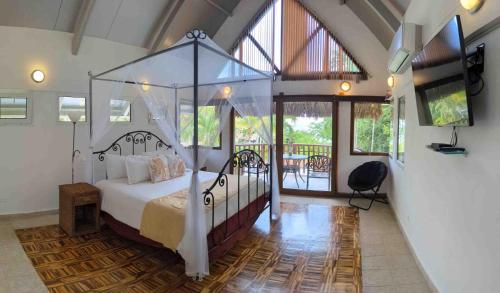 普拉亚布兰卡巴拿马瓜迪亚酒店的一间卧室设有一张天蓬床和一个阳台