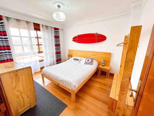 阿尔戈尼奥斯La Casa de Enzo的卧室配有一张床,墙上设有红色冲浪板