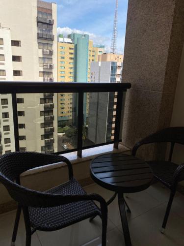 巴西利亚HOSPEDE-SE JÁ CULLINAN PARTICULAR的阳台配有两把椅子和一张桌子,还有一个窗户。