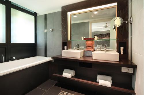 普纳奥亚Te Moana Tahiti Resort的浴室设有2个水槽、浴缸和镜子