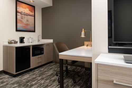 西雅图西雅图市区春山套房酒店的配有书桌和电视的酒店客房