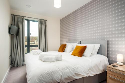 巴斯Solar Sanctuary- Skyline Balcony, City Centre, Three Floors, King Beds, Netflix and more!的卧室配有带橙色枕头的大型白色床